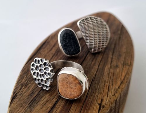 Four sterling silver statement rings with river stone, displayed on driftwood