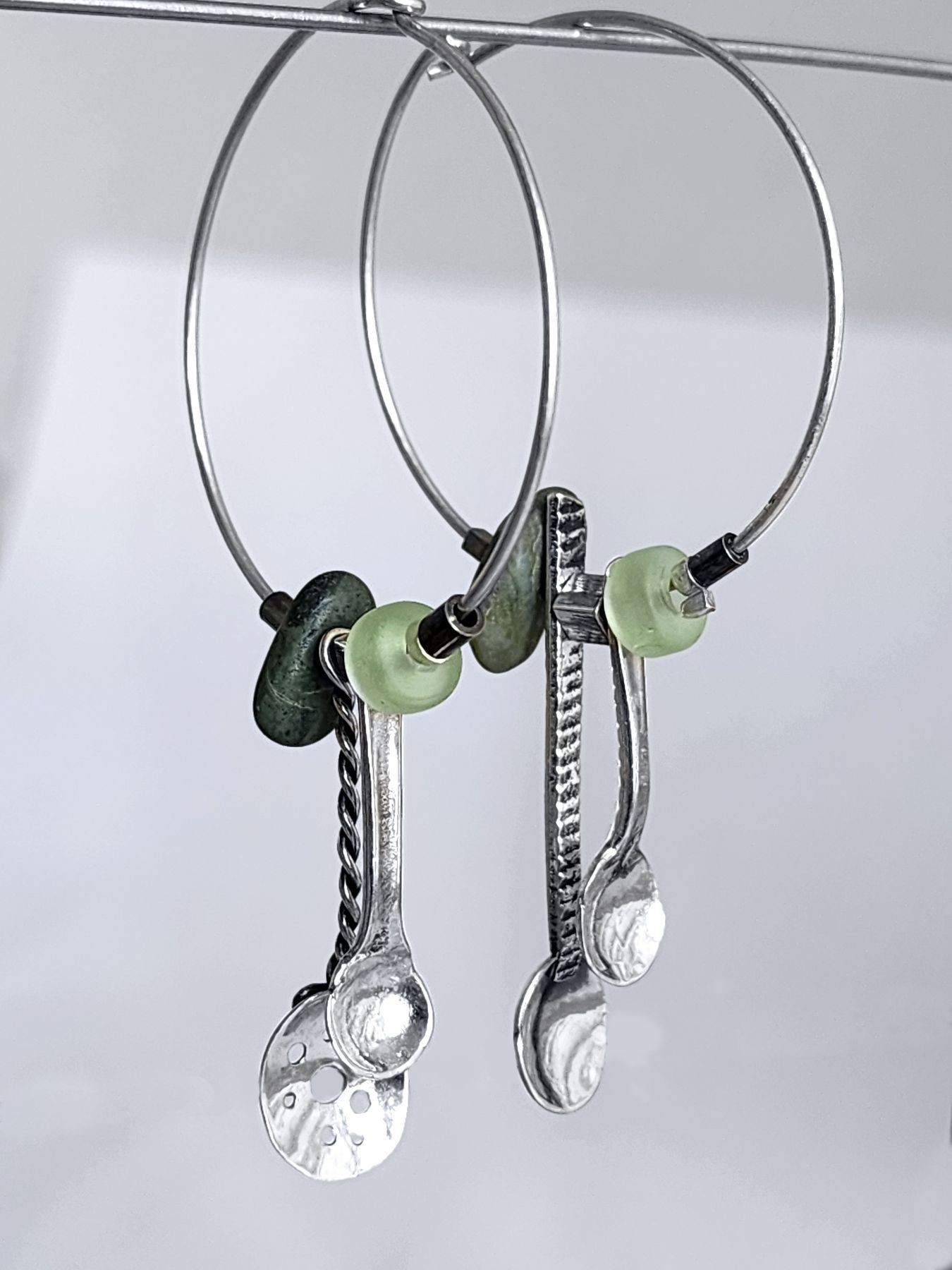 Silver hoop earrings with spoon charms and glass and pebble beads